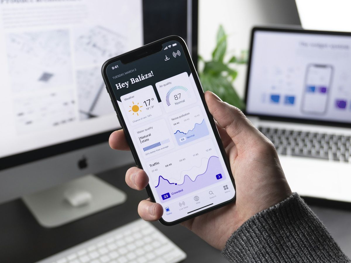 Hånd som holder en smarttelefon med en app åpen
