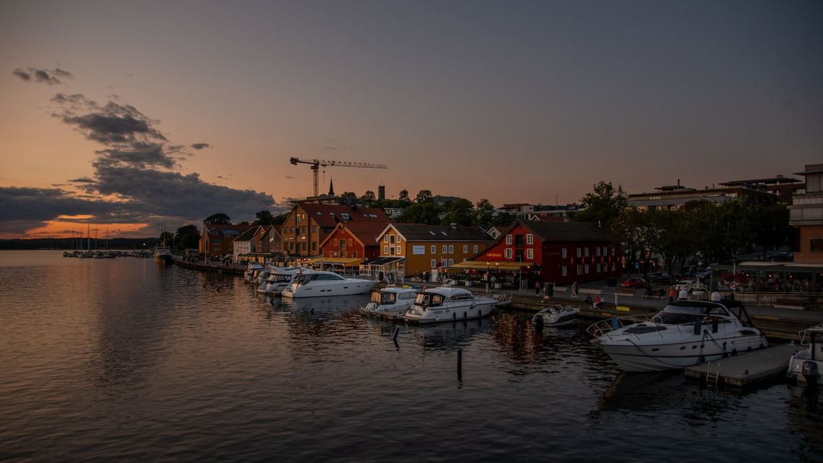 Tønsberg brygge med fritidsbåter i havna og Slottsfjellet i bakgrunnen ved solnedgang