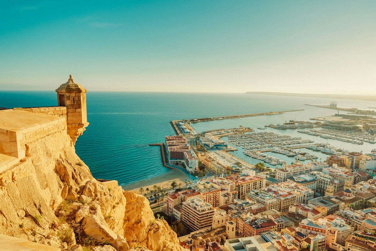 Alicante by med havn og festning i Spania