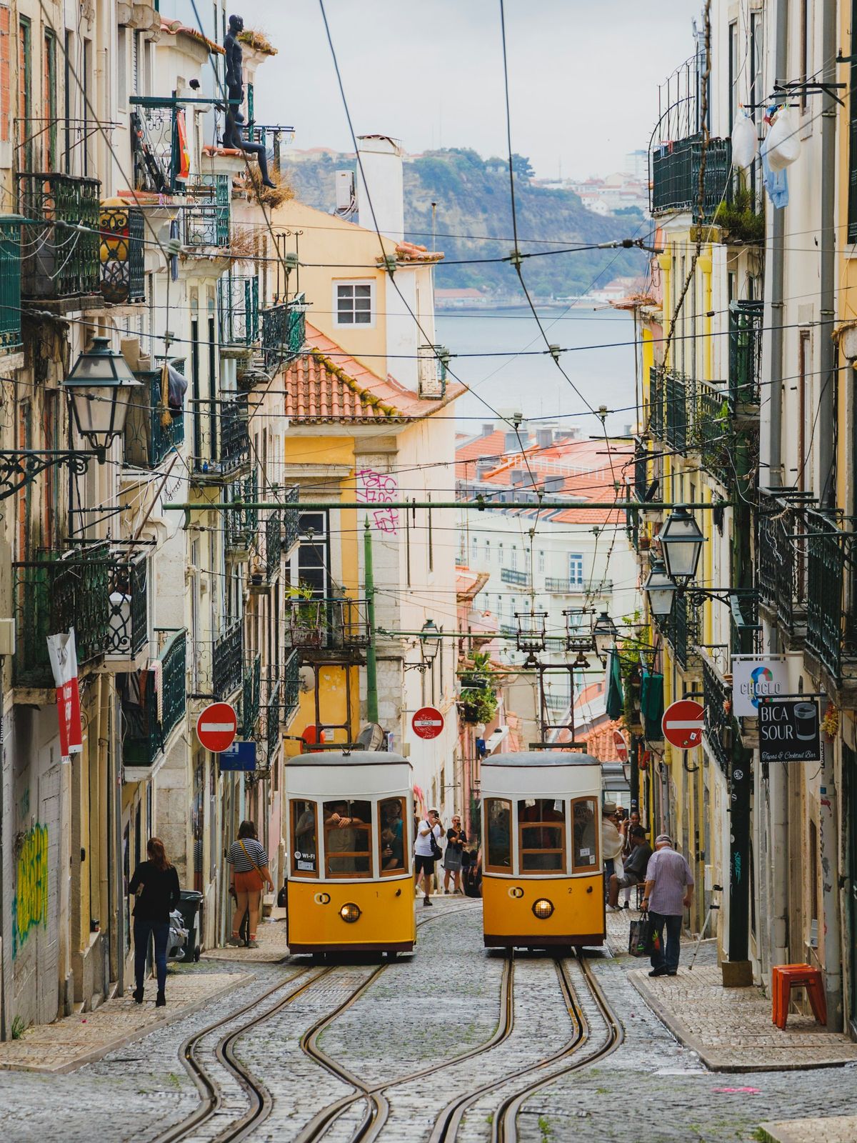 Gate i Lisboa med trikk og bybebyggelse